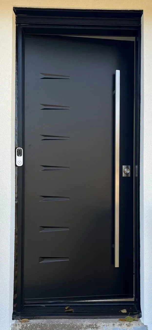 Modern matte black front door with long pull handle on a white Burlington exterior